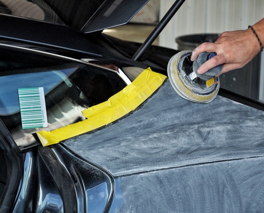 side panel of a vehicle being sanded and prepped